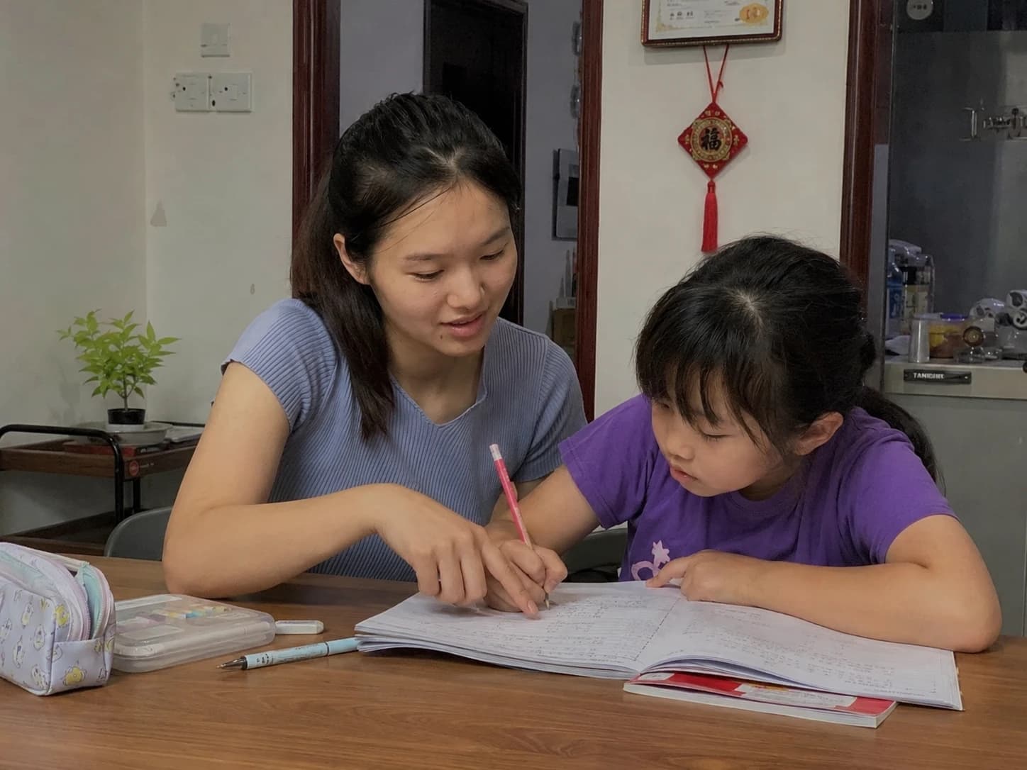 A tutor supporting a young student during a lesson